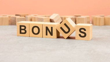 Tahta bloklardan yapılmış bir kelime. Metin siyah harflerle, hafif arkaplanla, iş konseptiyle yazılır