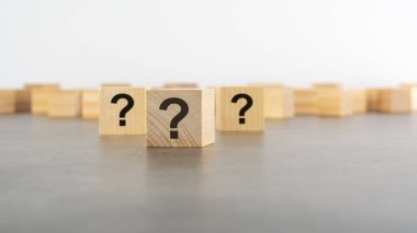 Tahta masada soru işareti olan üç tahta blok, yakın plan. Metin için boşluk. tahta arkaplan