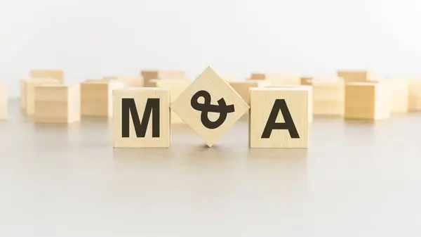 MA - Mergers and Acquisitions - letter pices on the wooden cubes, white background