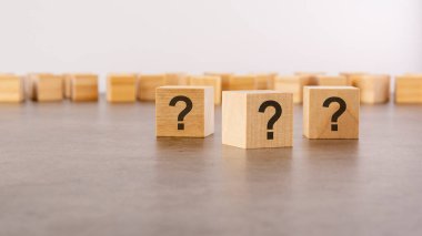 Tahta masada soru işareti olan üç tahta blok, yakın plan. Metin için boşluk. tahta arkaplan