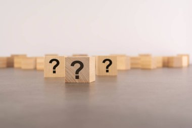 Tahta masada soru işareti olan üç tahta blok, yakın plan. Metin için boşluk. tahta arkaplan