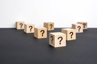 Pek çok tahta küpün önünde soru işaretleri var. Birçok soru ortaya çıkıyor. Sorun ve karışıklık. siyah ve beyaz arka grond