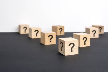 Pek çok tahta küpün önünde soru işaretleri var. Birçok soru ortaya çıkıyor. Sorun ve karışıklık. siyah ve beyaz arka grond