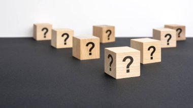 Pek çok tahta küpün önünde soru işaretleri var. Birçok soru ortaya çıkıyor. Sorun ve karışıklık. siyah ve beyaz arka grond