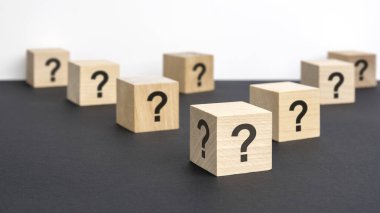 Pek çok tahta küpün önünde soru işaretleri var. Birçok soru ortaya çıkıyor. Sorun ve karışıklık. siyah ve beyaz arka grond