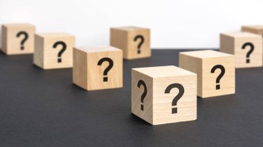 Pek çok tahta küpün önünde soru işaretleri var. Birçok soru ortaya çıkıyor. Sorun ve karışıklık. siyah ve beyaz arka grond