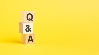 Tahta blokta sarı arkaplan ile Q ve A metni