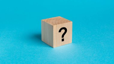 Soru işareti olan doğal ahşap küp, parlak mavi arkaplan