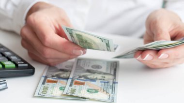 Tasarruf, finans, ekonomi ve ev konsepti - para sayan ve evde not tutan bir kadına yakın çekim