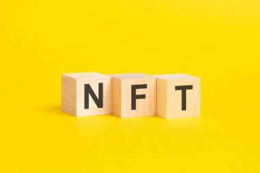Sarı kağıt üzerinde NFT-Fon Fonu Olmayan Simgeli tahta bloklar, iş kavramı