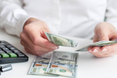 Tasarruf, finans, ekonomi konsepti - para sayan ve evde not tutan bir kadına yakın çekim