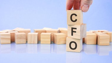 Metin finans müdürü parlak mavi bir yüzeydeki tahta küplere yazılmıştır. İş konsepti. Finans müdürü - finans müdürünün kısaltılmışı