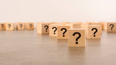 Pek çok tahta küpün önünde soru işaretleri var. Birçok soru ortaya çıkıyor. bela ve karmaşa