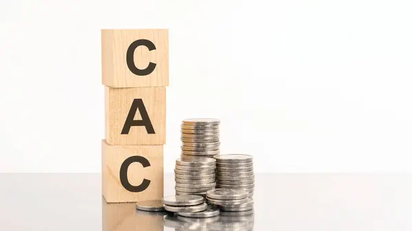 三个木制立方体与字母Cac 在白色的桌子和图表 商业概念 Cac 客户购置成本简称 免版税图库图片