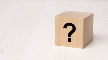 Ahşap masa arkasında siyah soru işareti olan tahta küp, iş ekibi konsepti