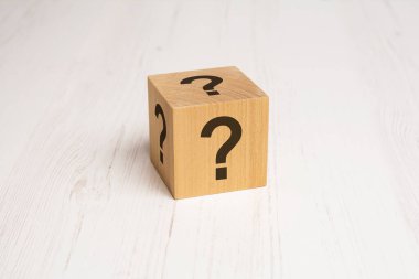 Tahta arka planda soru işareti olan küp. Metin için boşluk