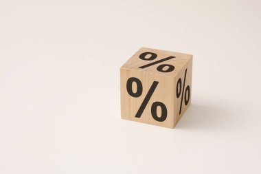 Beyaz arka plandaki yüzde işaretini değiştirmek için tahta bir kübik bloğu çevirmek. kredi geçmişi ve satış konsepti