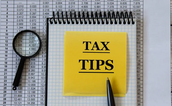 Tax Tips Woorden Een Wit Notitieboekje Achtergrond Van Een Tabel — Stockfoto