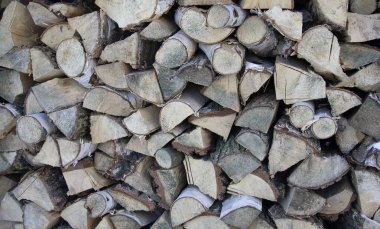 Evi yakmak ve ısıtmak için kesilen odunların ahşap arka planına dokunmuş. Odunları istiflenmiş bir odun yığını. huş ağacının dokusu.