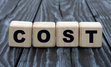 konsept kelime COST siyah ahşap arka plandaki küplere