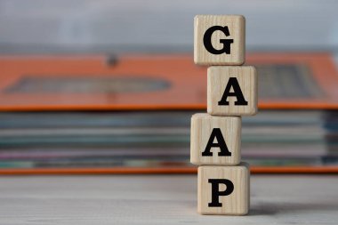 GAAP (Genel olarak Kabul Edilen Muhasebe İlkeleri) - bir klasörün arka planındaki tahta küplerin kısaltması. İş konsepti