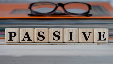 PASSIVE - evrak ve gözlüklü bir klasörün arka planında tahta küplerle ilgili bir kelime. İş konsepti