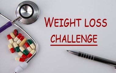 Kilo kaybı CHALLENGE - tablet ve steteskop ile hafif bir arkaplan üzerinde kelimeler
