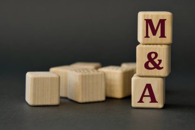 M ve A (Birleşmeler ve Satın Almalar) - Koyu arkaplanda tahta küplerin kısaltması. İş konsepti