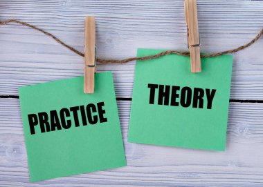 Pratik ve Teori - açık tahta arka planda mandalları olan yeşil kağıt parçaları üzerinde kelimeler. Bilgi kavramı