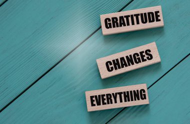 Minnettar olmak her şeyi değiştirir. Turkuaz bir arka planda tahta bloklardaki kelimeler. Eşit haklar sosyal konsepti