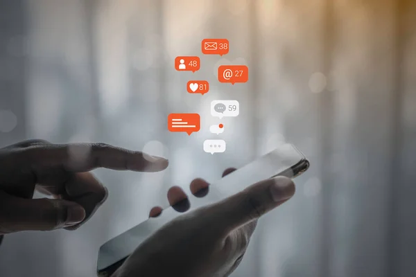 Cep telefonunda sosyal medya pazarlama kavramı kullanan kişi, bildirim simgeleri, mesaj, yorum ve akıllı telefon ekranının üstündeki yıldız gibi.
