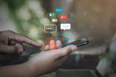 İş adamları cep telefonunda sosyal medya pazarlama kavramını kullanıyor. Bildirim simgeleri, mesaj, yorum ve akıllı telefon ekranının üstündeki yıldız gibi..