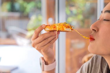 Seçici bir kadın pizza yiyor, ısırıldığında peyniri geriyor ve ağzından çıkartıyor. Lezzet ve kapanış gözlerini sanki inanılmaz bir lezzeti varmış gibi gösteriyor..