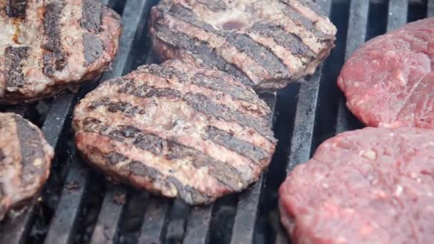 做汉堡包用的生肉丸子在烤架上煎 肉在户外烤肉架上烤着 烤肉上散热散烟 — 图库视频影像