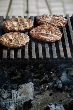 Hamburger için çiğ köfte ızgarada kızartılır. Et, açık havada barbekü ızgarasında kızarıyor..