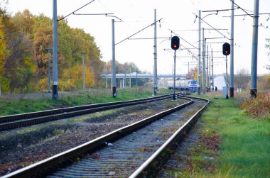 Demiryolu sonbahar ağaçları arasında yer alır. Sonbahar ormanlarından geçen sütunların yanındaki demiryolu ve yataklar. Sonbahar mevsimi konsepti. Tren otobanın altındaki raylarda çalışır..