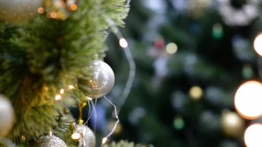 Geleneksel yapay Noel ağacı, altın top süsü ve arka planda fotokopi alanı ile parlayan renkli ışıklar. Yumuşak odaklı Noel süslemeleri. Mevsimlik kış tatili. Yeni yıl kavramı.