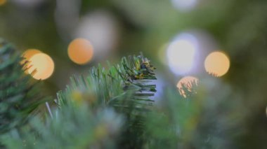 Fotokopi alanı ile parlayan renkli ışıkların arka planında geleneksel yapay Noel ağacı. Soyut Bulanık Noel Işıkları Bokeh Arkaplanı. Yeşil arka planda bulanık, altın rengi, yanıp sönen Noel ışıkları. Şenlik havası.