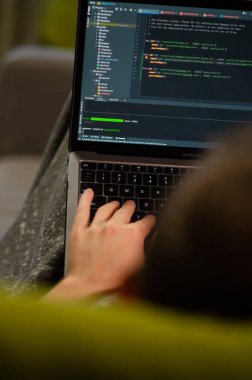 Londra, İngiltere - 12 Ocak 2022. Beyaz adam MacBook Air M1 kullanıyor. Programcı en son Apple dizüstü bilgisayarında kodlama yapıyor. Modern popüler meslekler kavramı. Dikey fotoğraf.