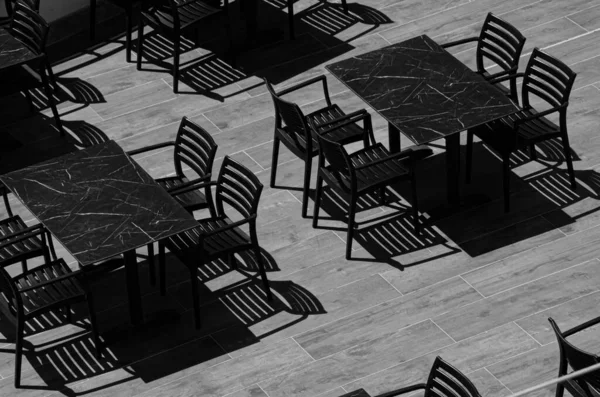 太陽の下でテラスのテーブルと椅子 モノクロームの写真 キッチン家具からの影 コピースペース付き表面テクスチャ — ストック写真