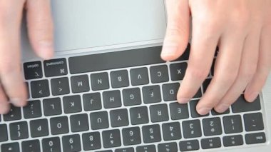Beyaz adam dizüstü bilgisayar kullanıyor. Şahıs kişisel bilgisayarda çalışıyor. Üst görünüm elleri cihazın klavyesinde. Serbest ve hareketlilik kavramı.