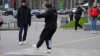 Kyiv, Ukrayna - 3 Mayıs 2021. Erkekler şehrin sokaklarında dans eder. Kaldırımda dans eden bir grup genç sokak sanatçısı. Sokak dansçıları şehir meydanında eğleniyor..