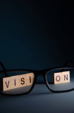 Vizyon bakım konsepti. Yazıt Vizyon, arka planda gözlüklü bulanık duruyor. Fotokopi alanı ile Harf İmgelemleri üzerine seçmeli odaklan. Mavi arkaplanda pankart.