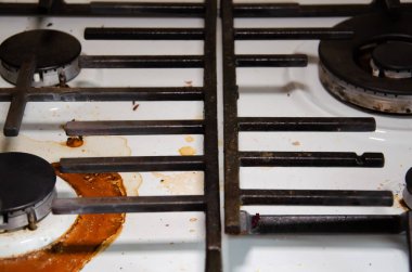 Fotokopi odası olan kirli gaz sobası mutfakta. Kurumuş yanık yağ lekelerinin içinde, gaz ocağıyla birlikte sobanın beyaz yüzeyi. Ev aletlerinin dikkatsiz kullanımı kavramı.