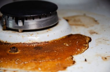 Fotokopi odası olan kirli gaz sobası mutfakta. Kurumuş yanık yağ lekelerinin içinde, gaz ocağıyla birlikte sobanın beyaz yüzeyi. Ev aletlerinin dikkatsiz kullanımı kavramı.