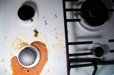 Fotokopi odası olan kirli gaz sobası mutfakta. Kurumuş yanık yağ lekelerinin içinde, gaz ocağıyla birlikte sobanın beyaz yüzeyi. Ev aletlerinin dikkatsiz kullanımı kavramı.