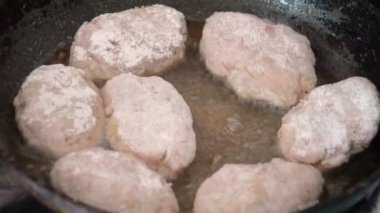 Kadınlar eski kızartma tavasında yağlı pirzola kızartıyorlar. Tavada köfte. Et tabağı ocakta hazır. Gerçek zamanlı yemek hazırlama videosu.