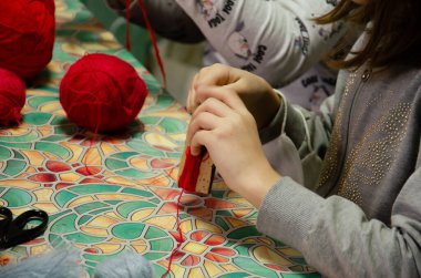 Kyiv, Ukrayna - 14 Şubat 2022. Çocuklar ipliklerden ürün yaparlar. Kafkasyalı ergen kızlar el işi yapar. Farklı aletleri olan kızlar için yüksek lisans sınıfı. Adım adım talimatlar.