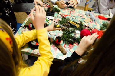 Kyiv, Ukrayna - 14 Şubat 2022. Çocuklar ipliklerden ürün yaparlar. Kafkasyalı ergen kızlar el işi yapar. Farklı aletleri olan kızlar için yüksek lisans sınıfı. Adım adım talimatlar.