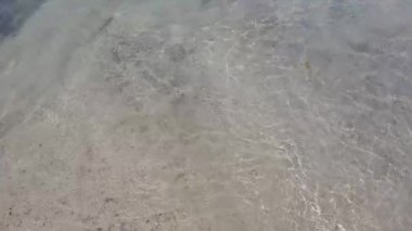 Dalgalanan berrak deniz suyunun doğal arka planı. Aquamarine deniz yüzeyinin havadan görünüşü. Sert deniz dokusu. Kopyalama alanı olan deniz teması.